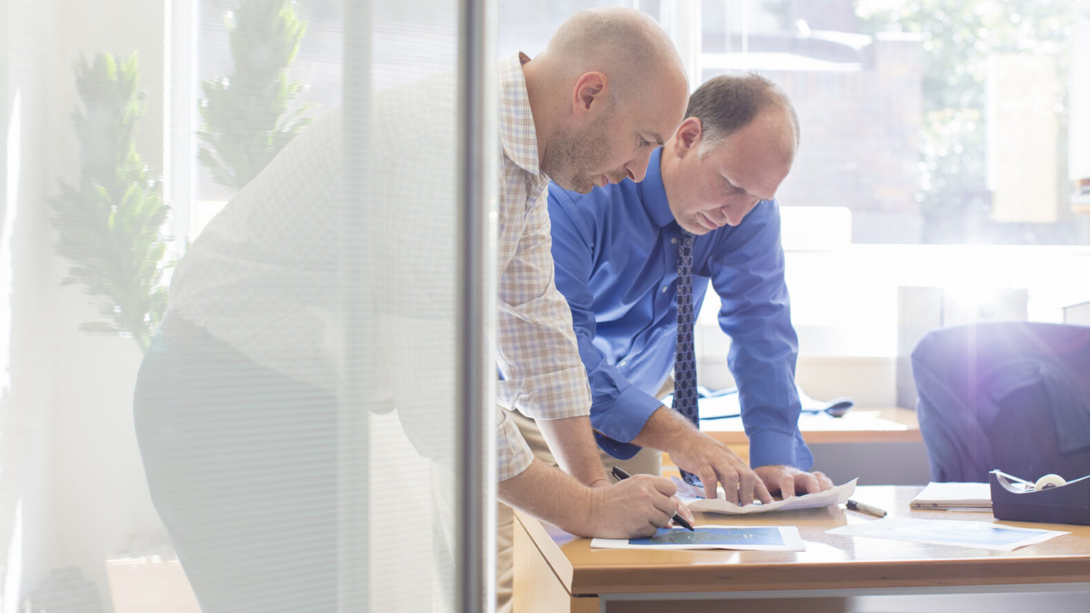 Professionally shot image of two male employees reviewing paperwork