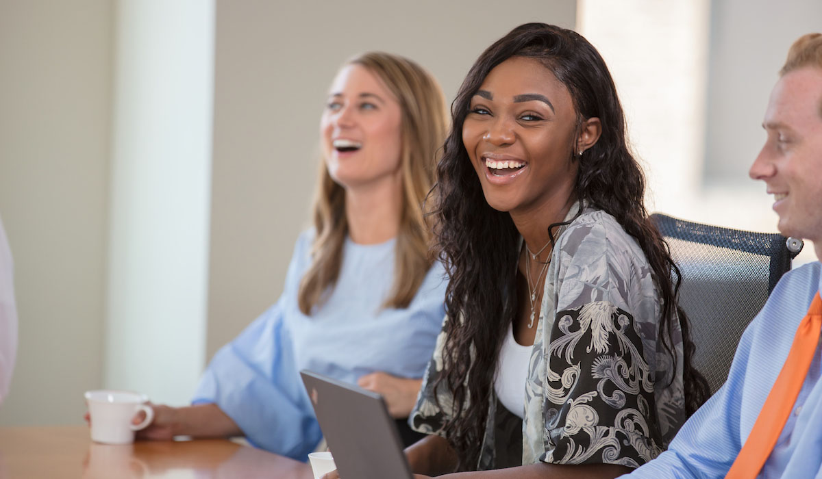 professional candid photo of employee laughing in corporate meeting