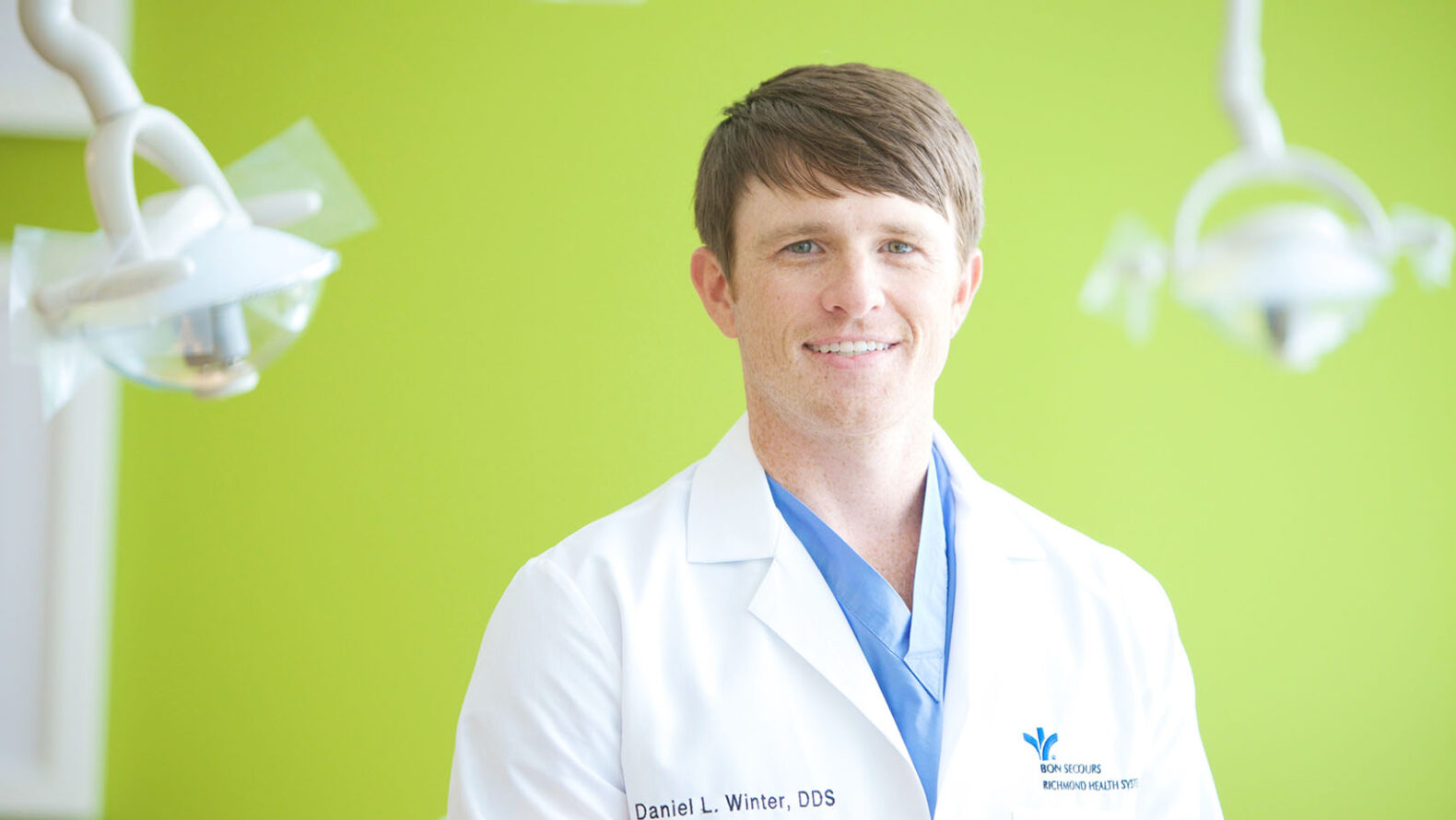 headshot of male doctor with brown hair and white jacket on