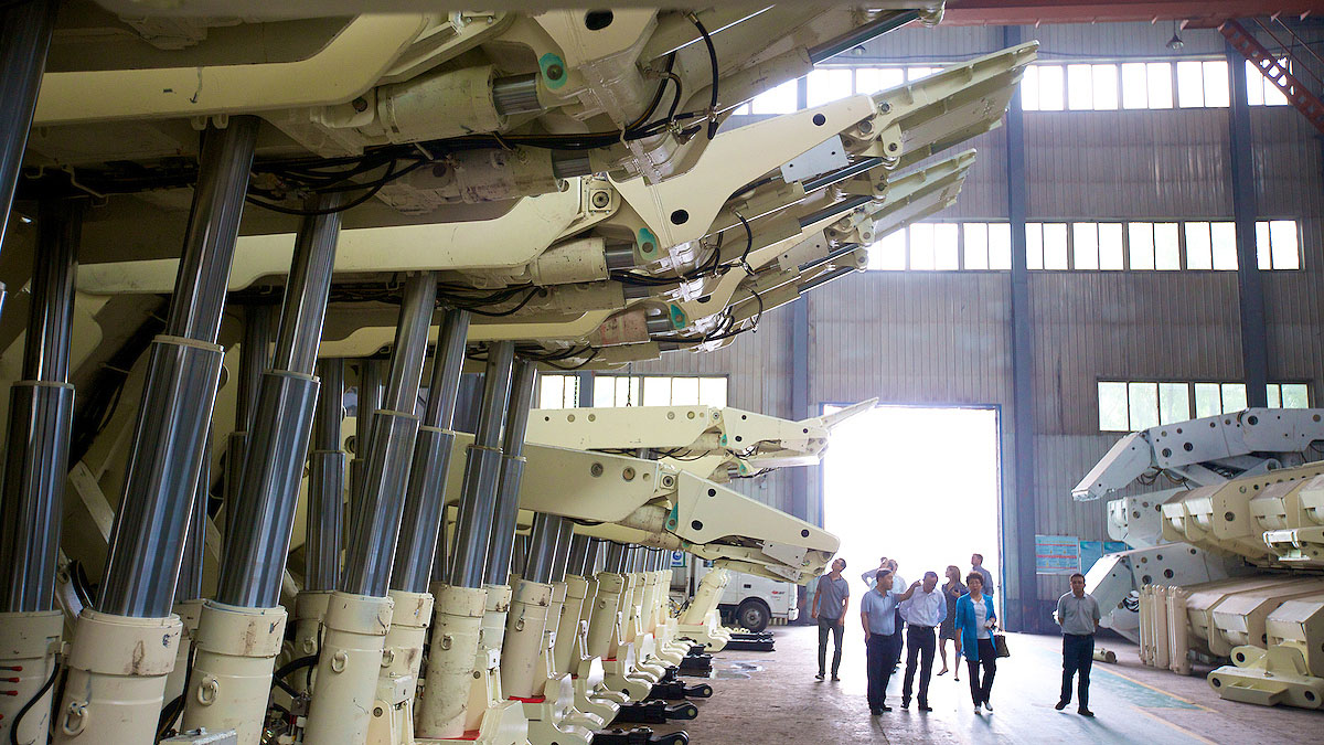 group of individuals walking through large manufacturing facility