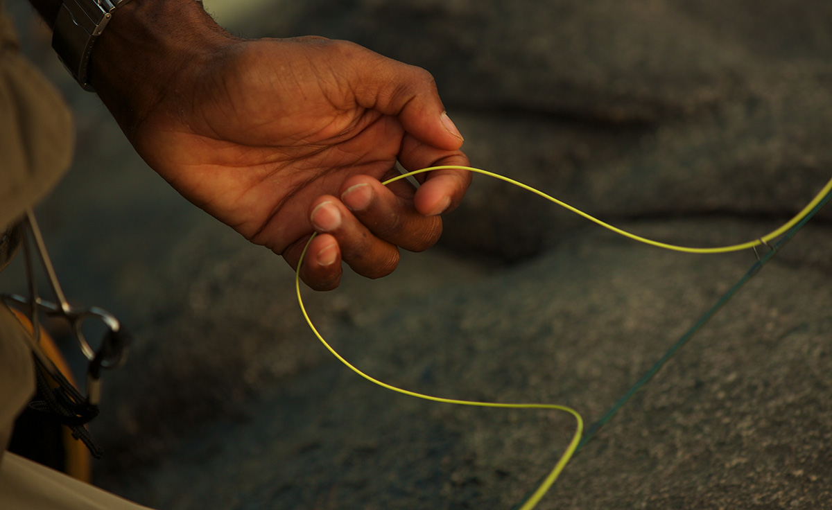 hand with yellow fishing line running through fingers