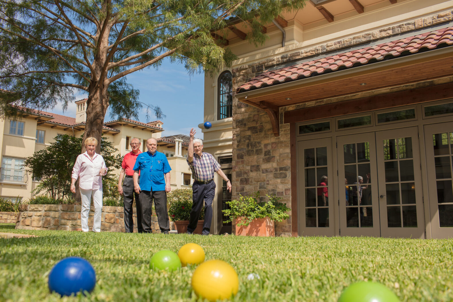 four senior living residents playing bocce ball