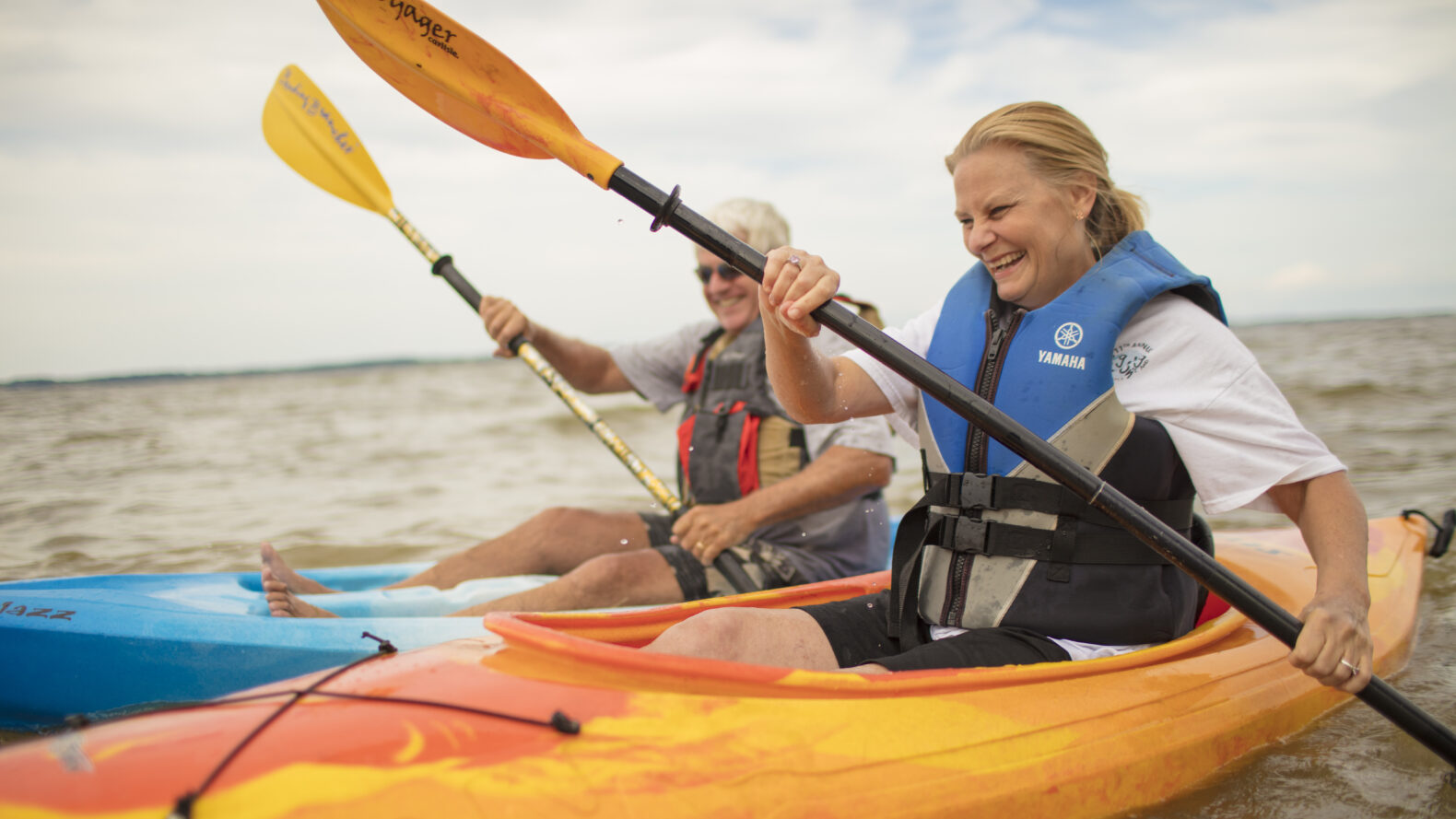 couple riding in two kayaks smiling