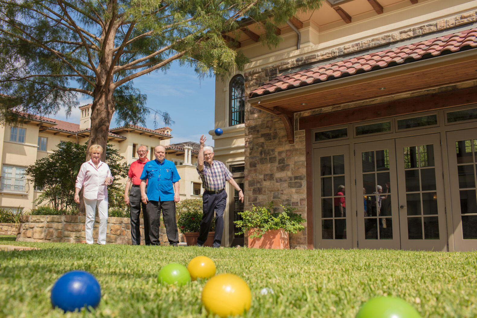 group of senior living residents playing bocce at facility
