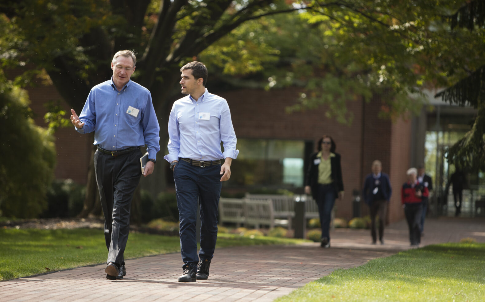 two coworkers walk outside while collaborating on marketing campaign