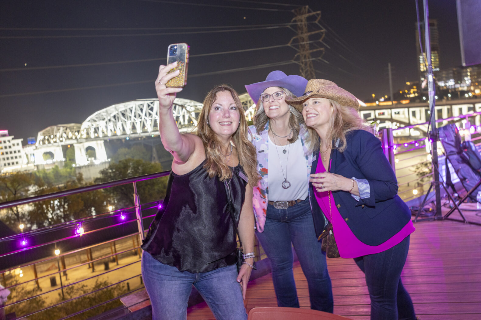 three females taking selfie picture outside at corporate event